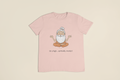 Pink t-shirt with a cartoon character and text on a beige background